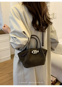 Detail of dark brown suede bucket bag with silver turn-lock and adjustable strap