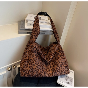 Detailed view of leopard print tote bag texture with adjustable buckle strap and zipper