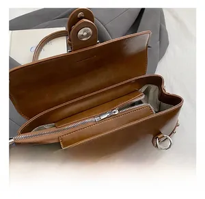 Détail de la fermeture éclair et de la doublure chevron d'un sac à main à rivets marron
