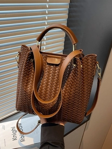 Brown woven bucket bag with top handle and adjustable shoulder strap in premium style