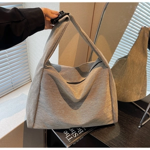 Macro detail of the grey minimalist tote bag with soft textured canvas and adjustable strap