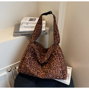 Detail of leopard print tote bag featuring wide black adjustable strap with buckle