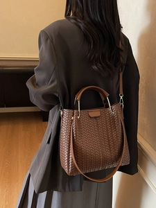Deep brown woven leather tote bag with round handles and adjustable shoulder strap