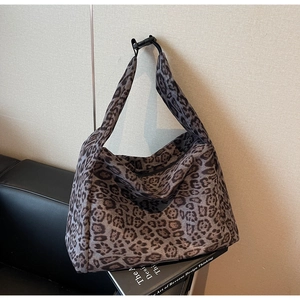 Detail of adjustable strap with black buckle on leopard print suede tote bag