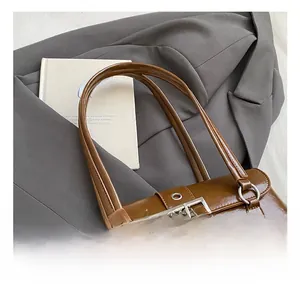 Gros plan d'un sac vintage marron foncé avec de larges boucles métalliques argentées