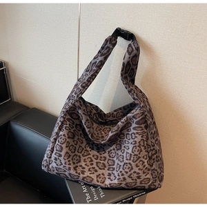 Close-up of leopard print faux suede tote bag featuring adjustable black plastic buckle strap
