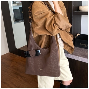 Vue détaillée du sac hobo en suédine avec bandoulière en perles et logo doré chic