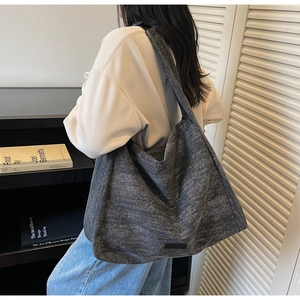 Detailed side view of large capacity dark grey textured tote bag with wide shoulder strap