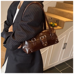 Gros plan d'un sac sous le bras marron foncé rétro en cuir ciré avec rivets et boucle