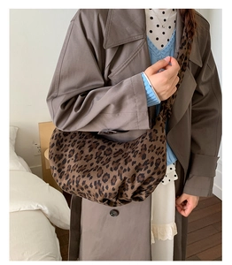 Detail of leopard print crescent bag showing soft fabric texture and crossbody fit