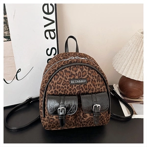 Gros plan du sac à dos léopard avec poches avant noir brillant et détails boucles argent