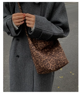 Close-up of leopard print shoulder bag with textured fabric shown on a grey coat