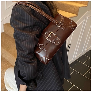 Détail du sac sous le bras en cuir ciré marron vintage avec rivets et boucles argentées