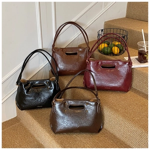 Close-up of four glossy textured leather tote bags in various retro colors on steps