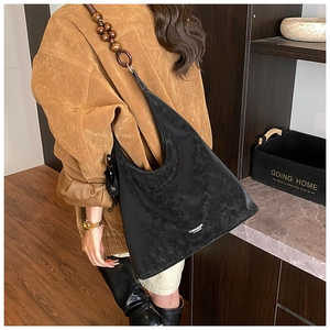 Dettaglio della borsa hobo vintage nera con perline di legno decorative e anello sulla tracolla