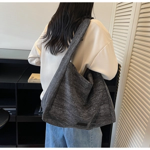 Detail view of large charcoal gray canvas tote bag featuring textured fabric and brand patch