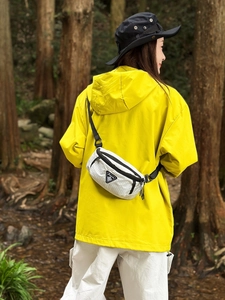 White checkered crossbody sling bag for outdoors with adjustable strap on a model