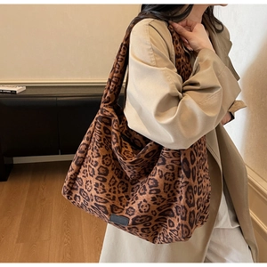 Detailed view of large leopard print tote bag with soft suede texture on a model