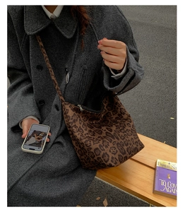 Detail of vintage leopard print hobo bag worn with a coat for an autumn casual look