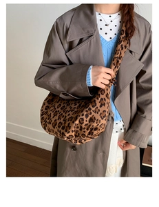 Detailed close-up of a large leopard print tote bag with soft fabric texture and draping
