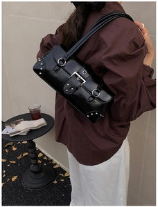 Détail du sac bandoulière en cuir ciré brillant avec boucles et rivets argentés