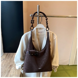 Détail du sac fourre-tout vintage marron avec anse en perles de bois et texture mate
