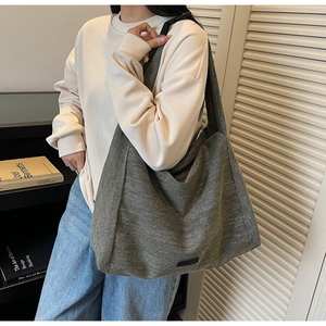 Close-up of deep grey-green canvas tote with black buckle strap and zip closure detail