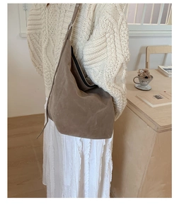 Brown suede hobo shoulder bag styled with beige sweater and white skirt for autumn