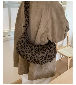 Detail of leopard print crossbody bag styled with a suede coat for a casual look