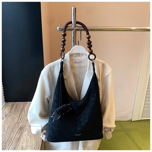 Détail du sac Hobo noir mat avec des perles en bois vintage sur la bandoulière