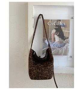 Close-up of leopard print shoulder bag featuring suede texture and zip closure design