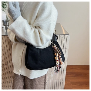 Détail du sac hobo en daim noir avec pampilles bohèmes et breloque en perles rétro