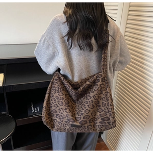 Detailed view of spacious leopard print tote bag on a shoulder in a stylish indoor setting