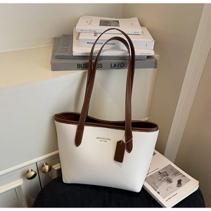 Gros plan d'un sac cabas minimaliste blanc et marron avec texture grainée et logo de marque