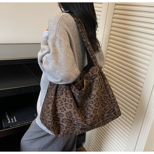 Detailed view of a leopard print suede tote bag worn over the shoulder for a casual style