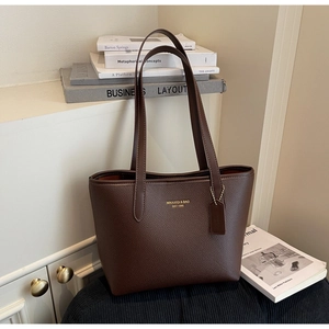 Détail de la texture litchi du sac cabas marron avec marquage doré élégant et chic