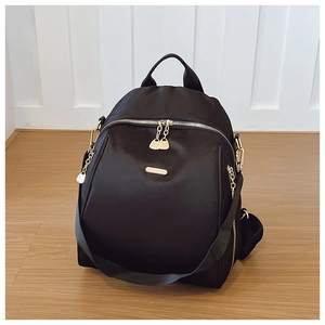 Close-up of black oxford backpack showing gold zippers and durable fabric texture