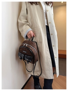 Gros plan du mini sac à dos à imprimé léopard avec poches en cuir et détails métalliques