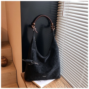 Dettaglio della borsa hobo nera con manico unico in perline di legno e logo in argento
