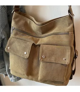 Detail view of khaki canvas crossbody bag featuring multi-pocket design and metal zippers