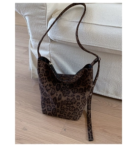 Detailed shot of leopard print hobo bag with adjustable grommet strap on a sofa
