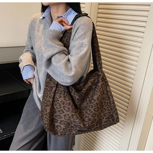 Detailed view of large leopard print tote bag worn with casual autumn outfit