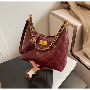 Détail du sac hobo matelassé bordeaux avec fermoir doré et bandoulière chaîne