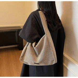 Detail showing high-capacity grey hobo tote bag with textured fabric and wide shoulder strap