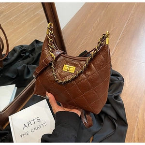 Détail du sac à bandoulière matelassé marron foncé avec fermoir en métal doré
