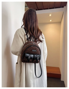 Détails d'un sac à dos léopard avec finitions en simili cuir et boucles métalliques