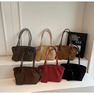Detail view of suede tote bag set in six colors showing matte texture and interior pouch