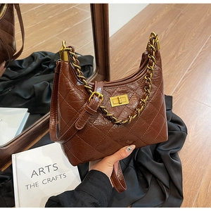 Vue détaillée du sac hobo en cuir matelassé marron foncé avec chaîne dorée et fermoir
