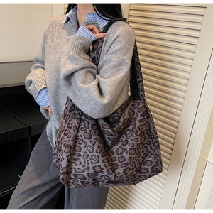 Macro shot of large leopard print tote bag showing thick canvas texture and wide strap