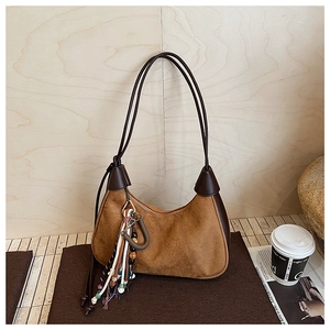 Vue détaillée du sac en daim marron avec pendentif à gland et fermeture éclair chic